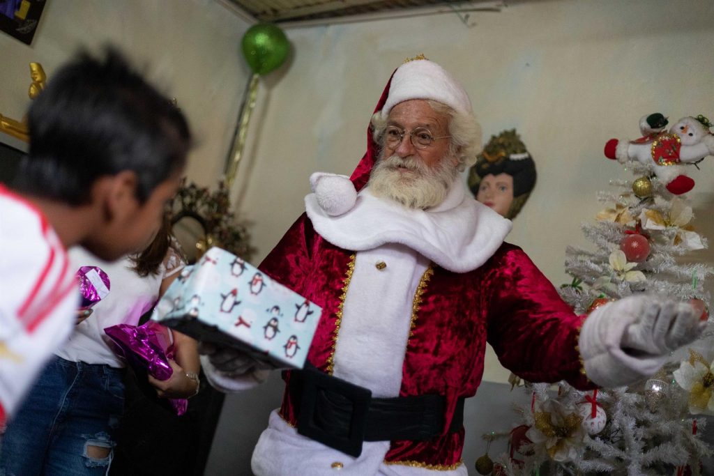Santa Claus comienza a repartir regalos con la ayuda de sus renos